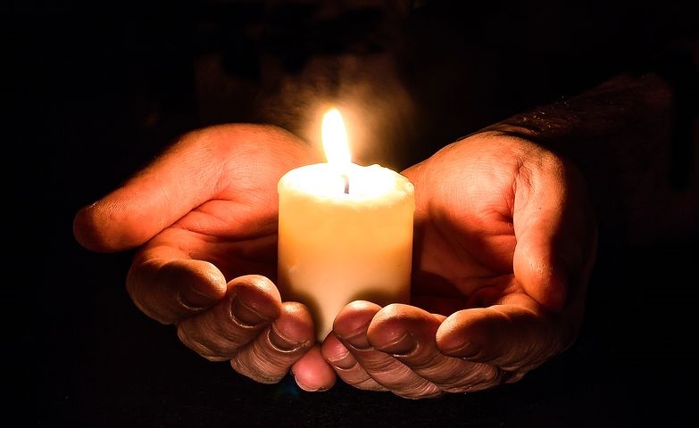 Hands around a candle